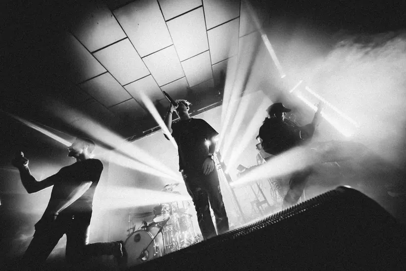 Retrace The Lines on stage, shot from the floor, beams of light cutting through smoke