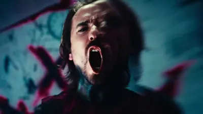Still from the Pain video: a long-haired figure screaming under teal light